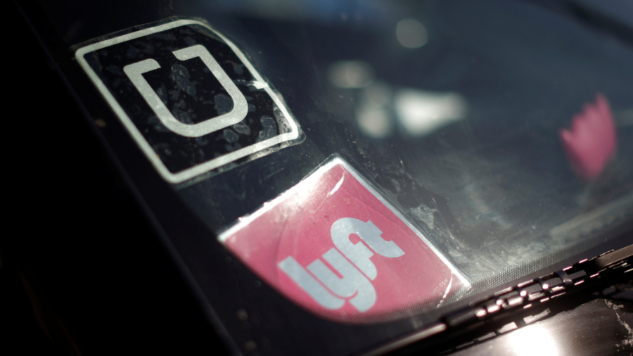 File photo of a  driver displaying Uber and Lyft ride sharing signs on his car windscreen in Santa Monica