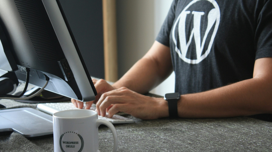 person in black and white t-shirt using computer